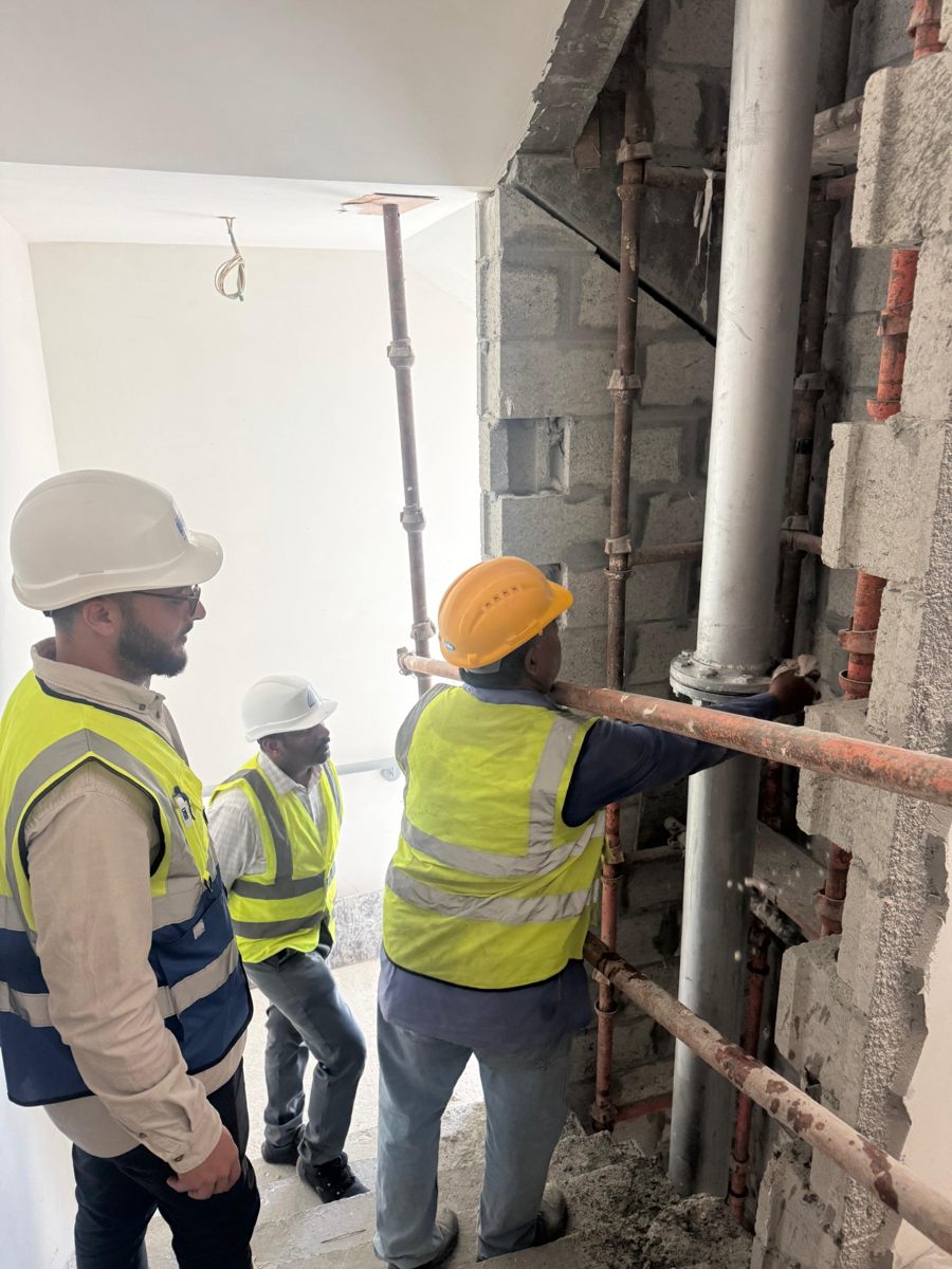 Personnel inspecting vertical mechanical piping at a construction site